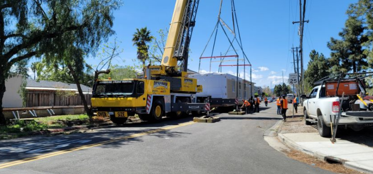 modular home crane delivery with street closure and crew on site
